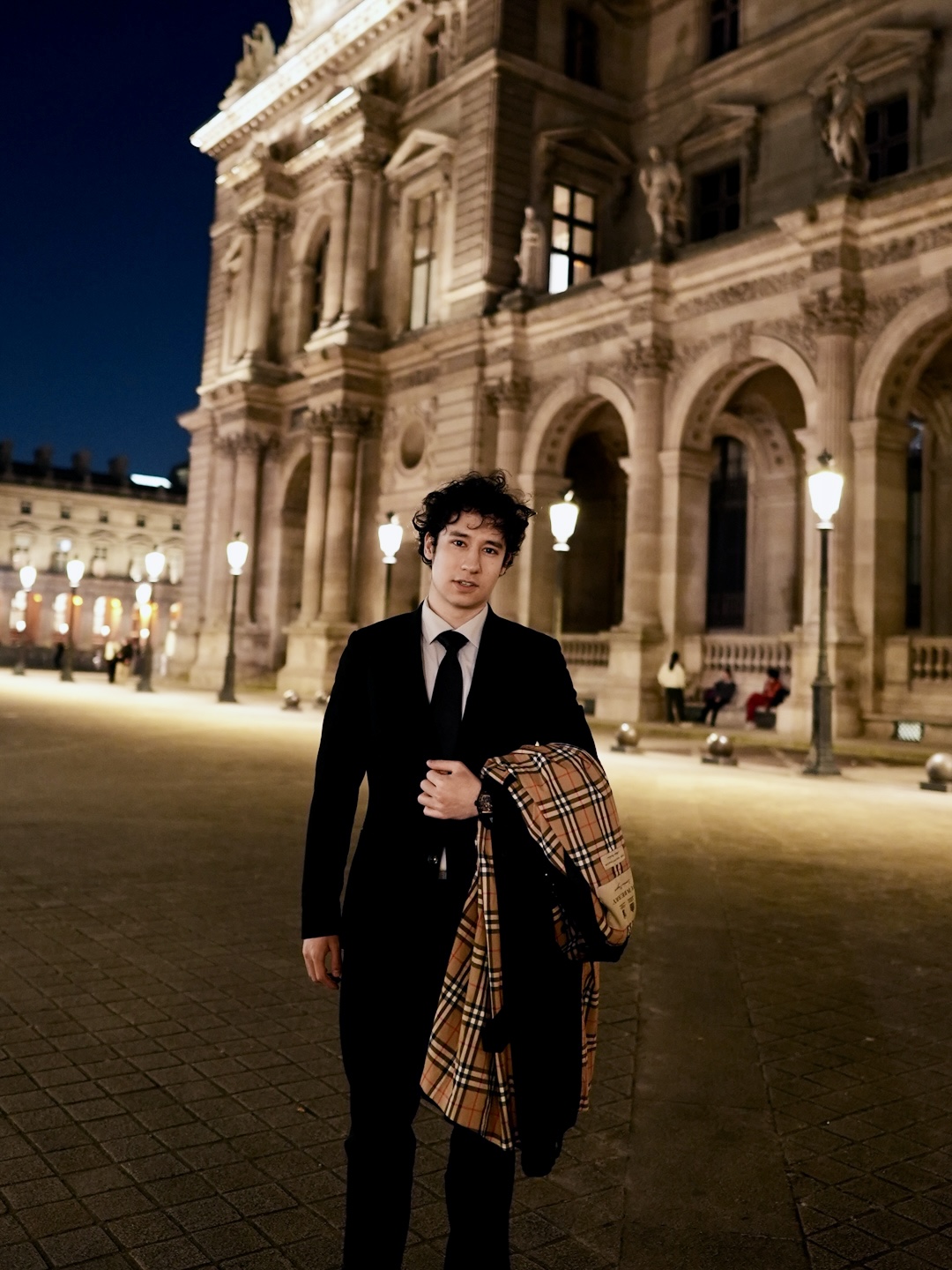 Joshua Kyan Aalampour in an illuminated architectural square at night